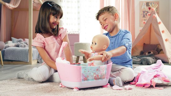 Jongen en meisje spelen met een roze badje met Baby Annabell pop. Het badje heeft witte schaapjesvoetjes.