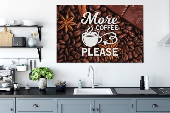 Canvasdoek met de tekst 'More coffee please' tussen koffiebonen, steranijs, kaneelstokje en chocolade, boven een aanrecht in een keuken.