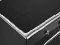 Detail van zwarte inductiekookplaat met metalen rand en draaiknop.