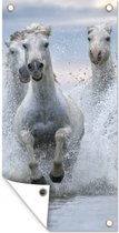 Tuinposter Kudde witte paarden galoppeert door het water in Camargue - 40x80 cm - Wanddecoratie Buiten - Tuinposter - Tuindoek - Schuttingposter - Tuinschilderij