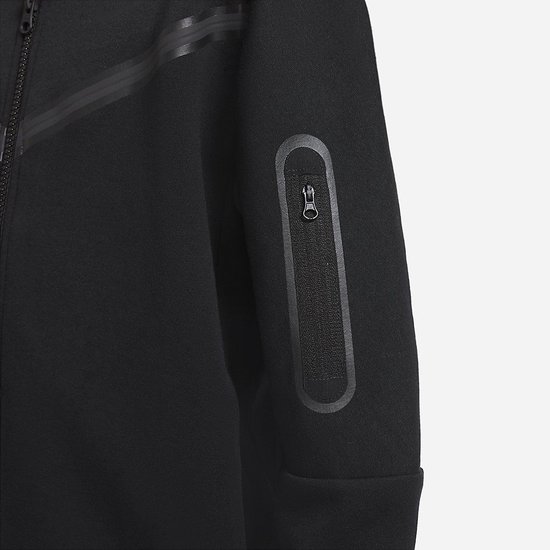 Detail van de mouw van een zwart Nike Tech Fleece vest met een ritszakje.