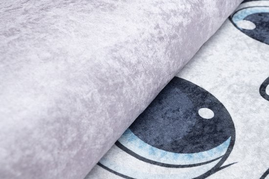 Gros plan d'un tapis rose texturé et d'une partie d'un œil de chat.