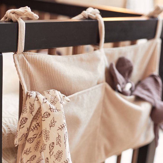 Lichtbeige corduroy boxopberger met bruine knuffels en een plantenprint doekje.
