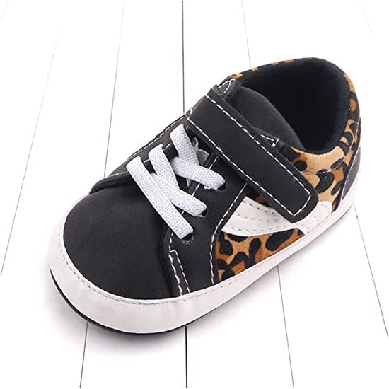 Zwarte babysneaker met luipaardprint op de zijkant, witte veters en klittenbandsluiting.
