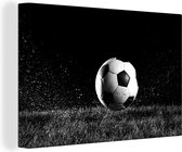 Canvas Schilderij Voetbal in het gras - zwart wit - 90x60 cm - Wanddecoratie