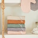 Stapel van zes babybadcapes in verschillende kleuren: beige, bruin, groen, grijs en roze.