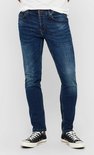 Man in een strakke, donkerblauwe jeans met lichte wassing en verfspatten.