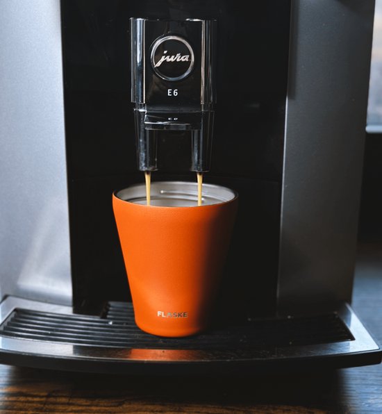 Oranje FLASKE beker die koffie ontvangt van een Jura E6 koffiezetapparaat.