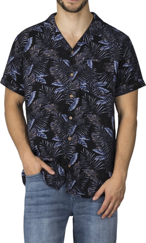 Man met korte mouwen, zwart overhemd met tropisch bladmotief in blauw, paars en bruin, met spijkerbroek.
