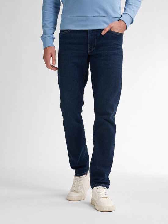 Mannequin portant un jean bleu foncé légèrement délavé, un sweat bleu clair et des baskets blanches.