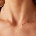 Zilverkleurige slangenketting gedragen door een vrouw