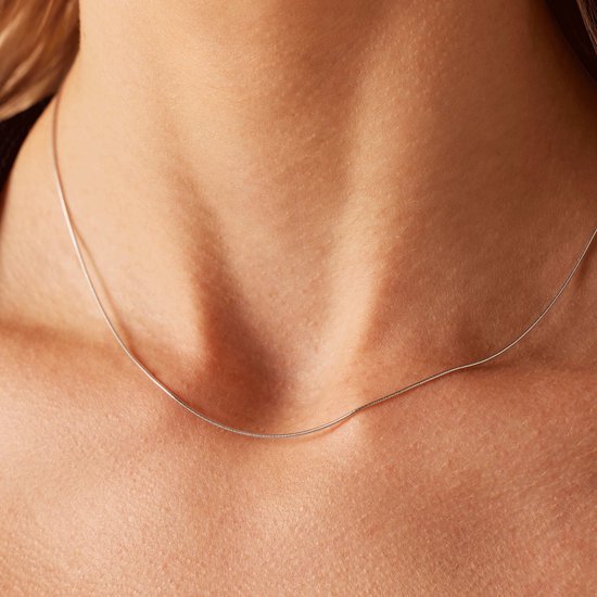 Zilverkleurige slangenketting gedragen door een vrouw