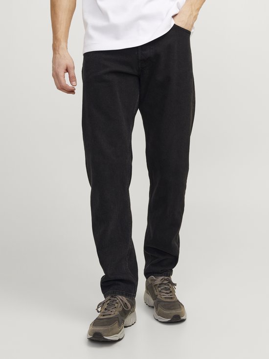 Losse zwarte denim jeans gedragen door een man.
