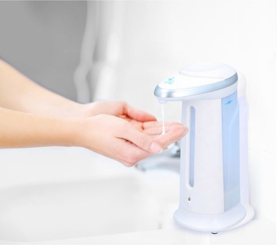 Witte automatische zeepdispenser met zilveren accenten, zeep wordt gedispenseerd in handen.