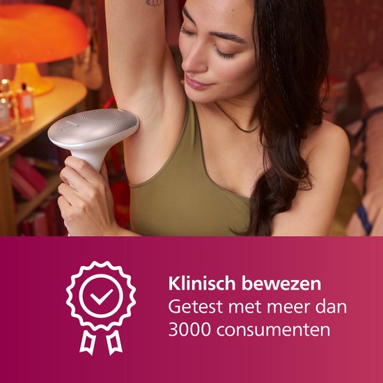 Vrouw met donker haar gebruikt het witte Philips Lumea IPL ontharingsapparaat op haar oksel.