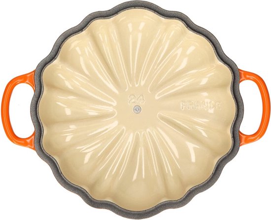 Onderkant van oranjerode pompoen braadpan met crèmekleurige binnenkant en "FRANCE" vermelding.