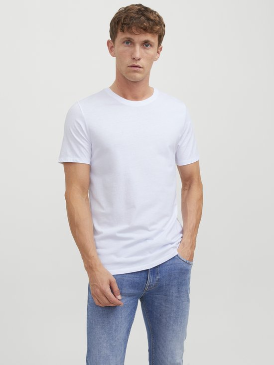 Man met korte mouwen, ronde hals, witte T-shirt en blauwe jeans.