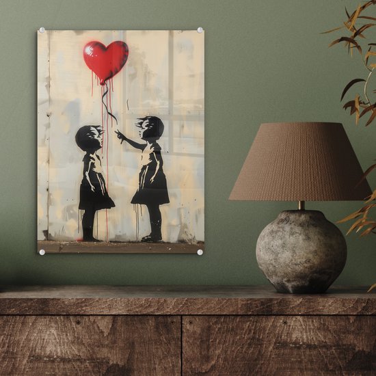 Acrylglas schilderij van twee kinderen met een rode ballon in hartvorm, hangend aan een groene muur met lamp.