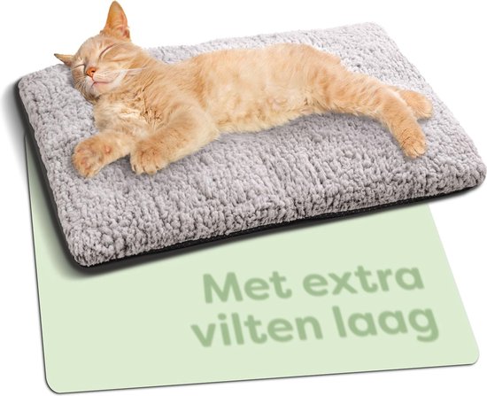 Een oranje kat slaapt op een grijze, zachte vachtmat.