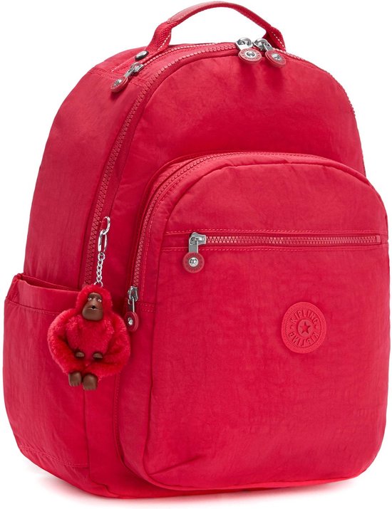 Sac à dos Kipling rouge avec porte-clés singe rouge, une poche avant zippée et des poches latérales.
