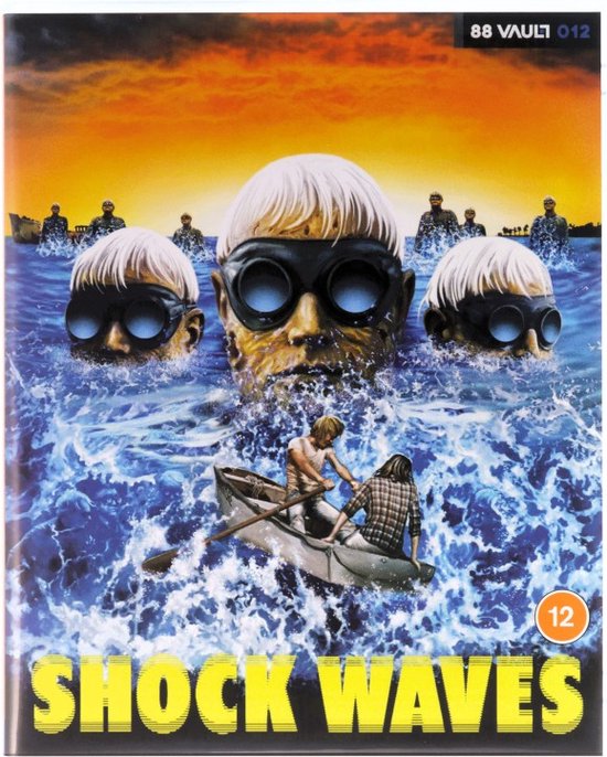 Drie hoofden met duikbrillen drijven in woelig water, een bootje met twee personen vaart naar hen toe. "SHOCK WAVES" staat onderaan.