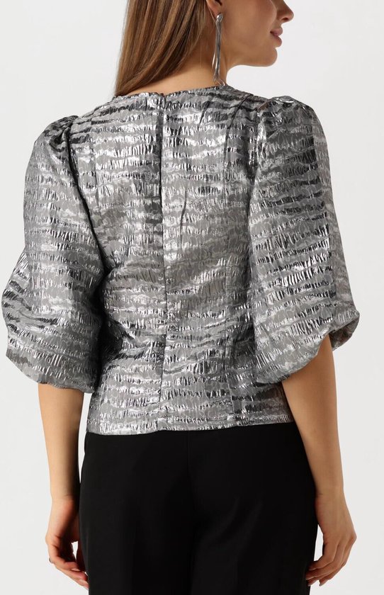 Model draagt zilveren blouse met pofmouwen en V-hals, van achteren gezien.