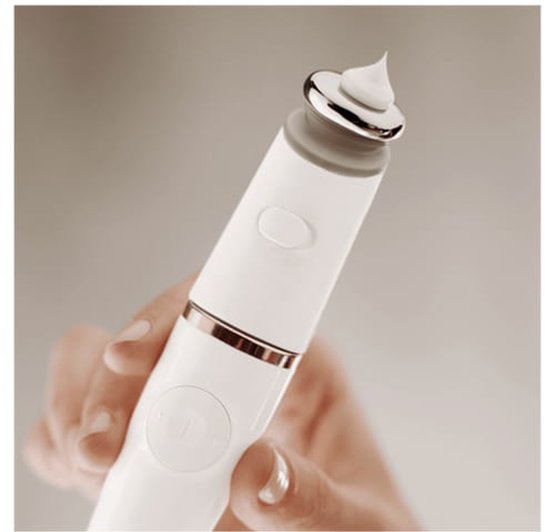 Hand houdt witte epilator met rosegouden accenten en een kleine hoeveelheid witte crème op de metalen kop.