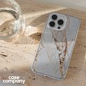 Telefoon met marmeren hoesje naast een glas water.
