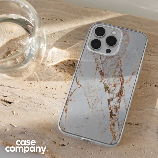 Telefoon met marmeren hoesje naast een glas water.