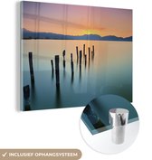MuchoWow® Glasschilderij 80x60 cm - Schilderij acrylglas - Palen in het kalme water bij zonsondergang - Foto op glas - Schilderijen