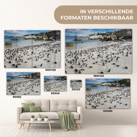 Meerdere maten van een glazen schilderij met pinguïns op het strand, naast een bank.