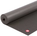 Grijze Manduka yogamat, deels opgerold, met rood logo.