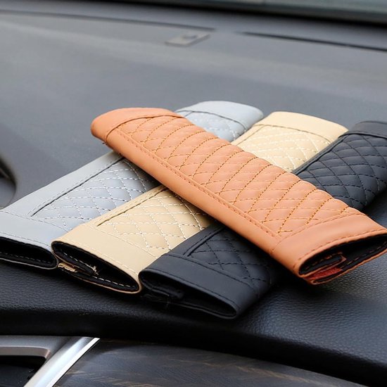 Set gordelhoezen in verschillende kleuren, waaronder bruin, beige, grijs en zwart, op een dashboard.