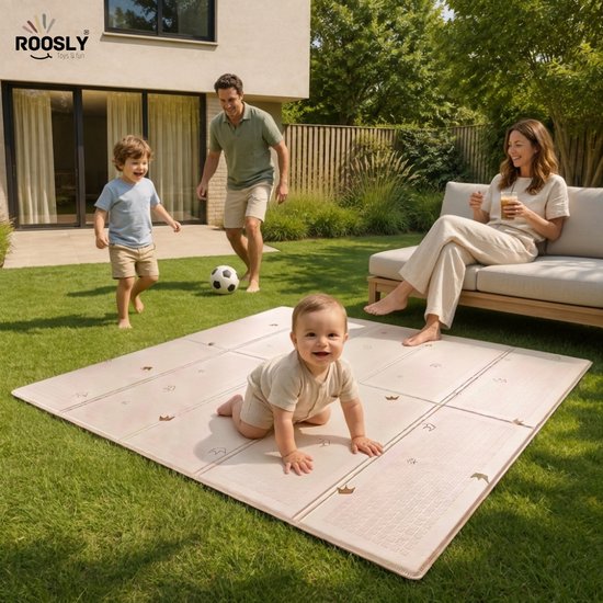 Beige speelmat van 180 x 200 cm met subtiele gouden kronen, op het gras in een tuin. Een baby speelt erop, terwijl een gezin in de achtergrond zit.