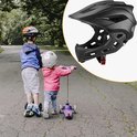 Zwarte kinderhelm met verwijderbare kinbeschermer, twee kinderen op steps.