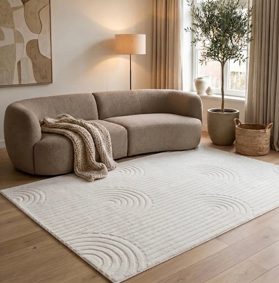 Tapis crème à poils courts avec motif de lignes courbes, présenté dans un salon avec un canapé beige.