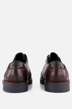 Achterkant van een paar bruine leren veterschoenen met donkerblauwe hielaccenten en grijze zolen.