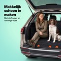Une femme et un chien sont assis sur une housse de voiture noire matelassée dans un coffre ouvert. La housse est facile à nettoyer.