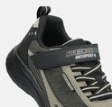 Detail van zwarte sneaker met klittenband met 'Skechers Waterproof' tekst. Grijze en beige mesh.