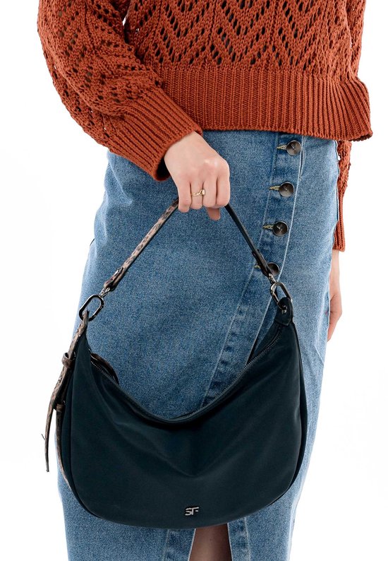 Een model draagt een donkerblauwe SURI FREY schoudertas met panterprint band en bruine gebreide trui.