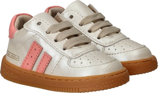 Paar licht gouden leren sneakers met roze strepen, bruine zool en veter sluiting.