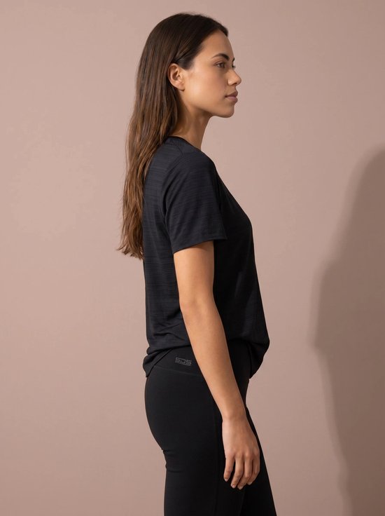Vrouw in donkerblauw sportshirt met korte mouwen, van de zijkant gezien. Logo op linkerheup.
