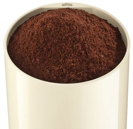 Een beige koffiemolen gevuld met gemalen bruine koffie.