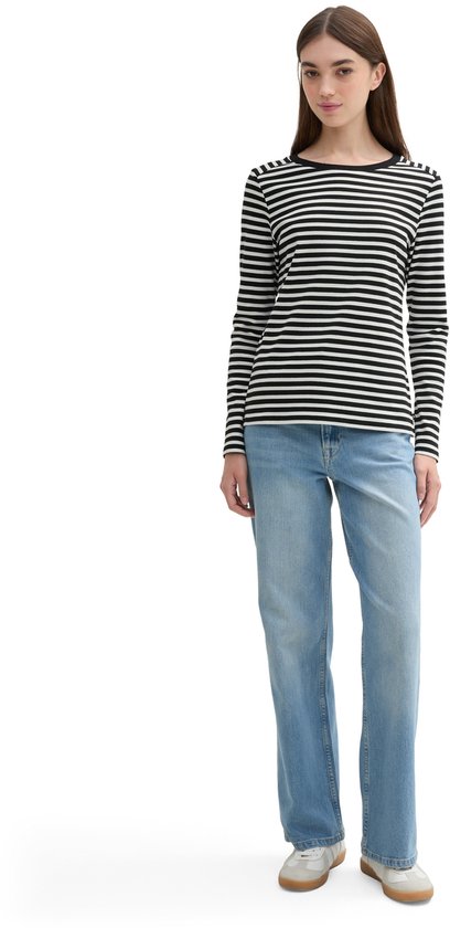 Model draagt zwart-wit gestreept T-shirt met lange mouwen en een zwarte boothals, met spijkerbroek.