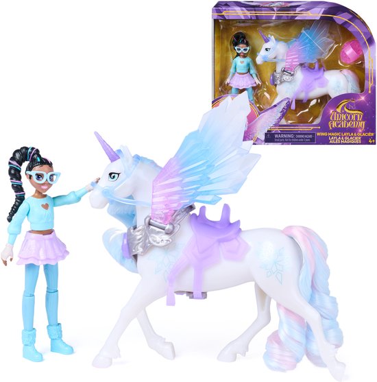 Een pop met bril en eenhoorn met vleugels en zadel, met de verpakking van 'Unicorn Academy' op de achtergrond.