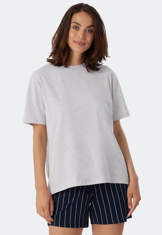 Une femme porte un t-shirt gris chiné à manches courtes.