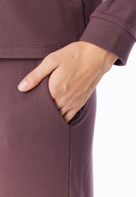 Gedetailleerde opname van de zak van een donkerpaarse pyjamabroek.