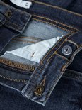Detail van de tailleband van een donkerblauwe spijkerbroek, met knoop, rits en verstelbare tailleband.