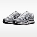 Paar grijze Nike P-6000 sneakers met metallic zilveren finish en zwarte accenten, op een witte achtergrond.