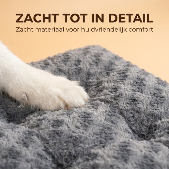 Close-up van een poot van een witte hond op een zacht, grijs, fluffy hondenkussen.